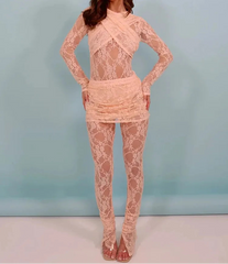 Woman wearing a pink lace outfit against a light blue background