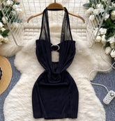 Black halter top on a hanger with decorative elements in the background