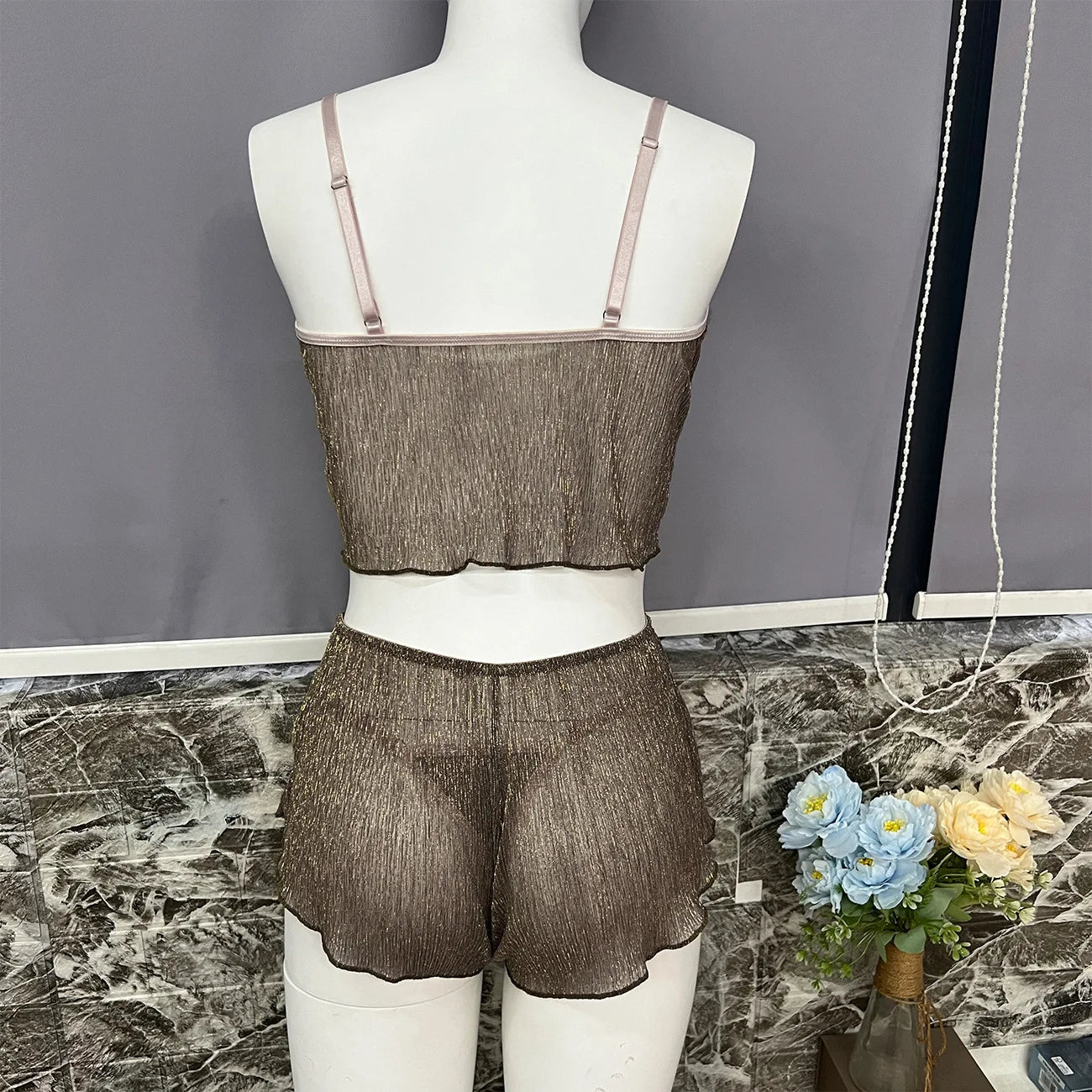 Sheer brown lingerie set on a mannequin against a gray wall.