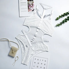 White lace lingerie set on a light gray surface with decorative elements.