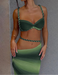 Woman wearing a green bikini with a gradient skirt against a gray background