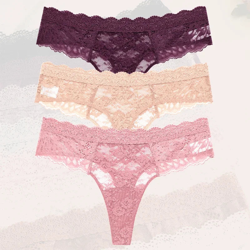 Three pairs of lace underwear in purple, pink, and beige on a textured white background.