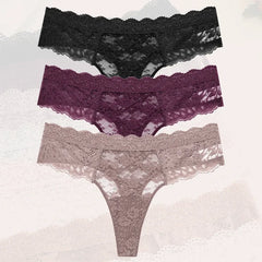 Three pairs of lace underwear in black, purple, and gray on a textured white background.