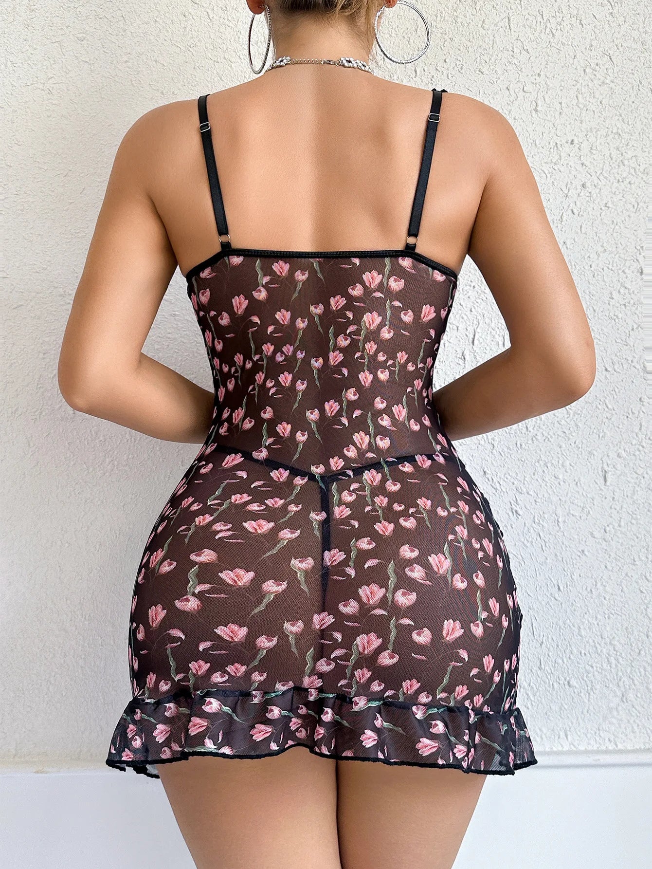 Woman wearing a floral patterned nightgown against a white background