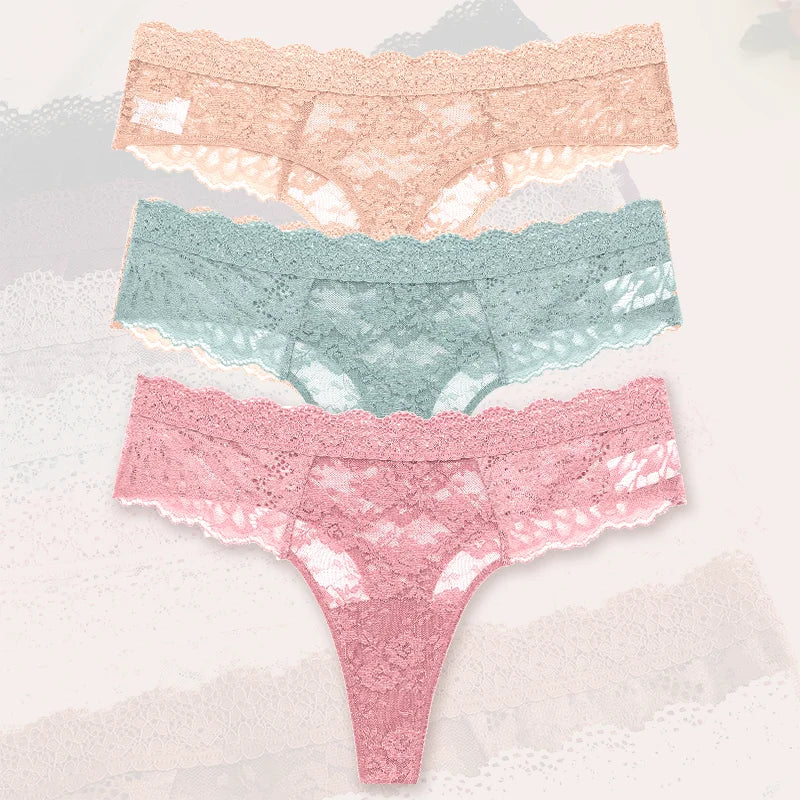 Three pairs of lace underwear in pink, green, and blue on a textured white background.