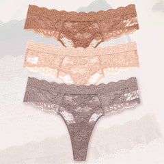 Three pairs of lace underwear in different colors on a textured surface.