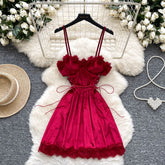 Red dress on a hanger with decorative elements on a gray surface