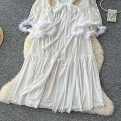 White lace dress with fluffy trim on a textured surface