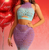 Woman in a matching lace top and skirt with 'Love' balloons on a red background