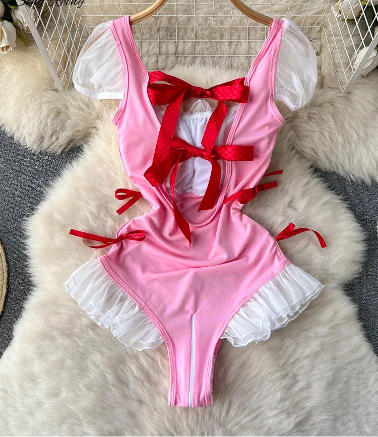 Pink swimsuit with red bows on a hanger against a textured white background