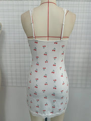 White dress with cherry pattern on a mannequin against a grid background