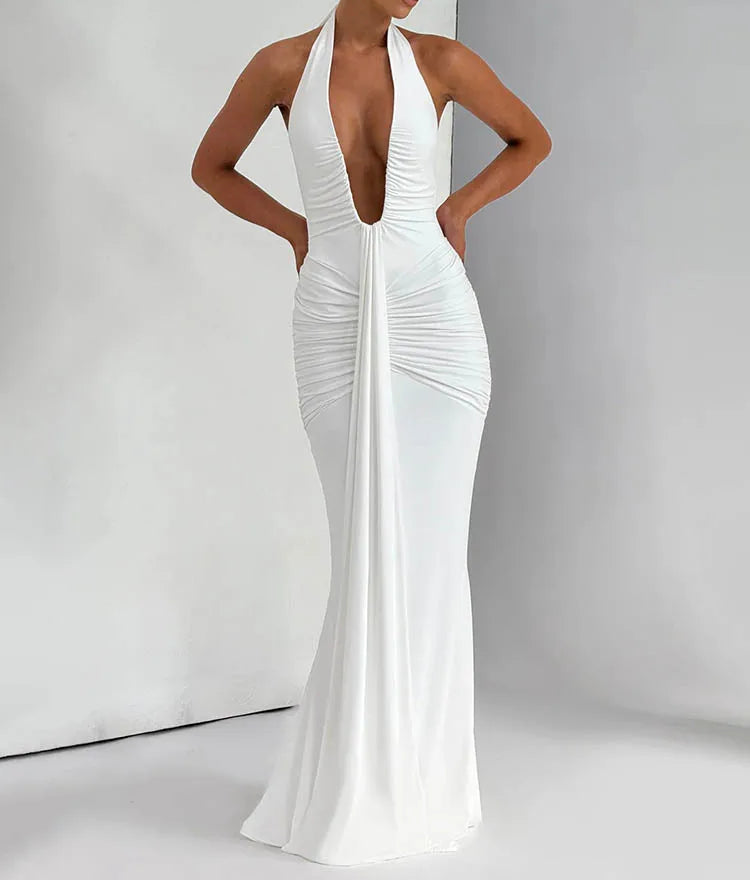 Woman wearing a white evening gown with a deep neckline on a plain background