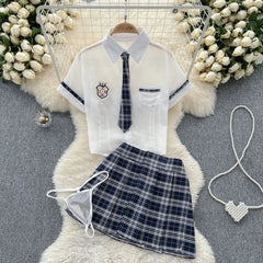 School uniform with white shirt, tie, and plaid skirt on a floral background