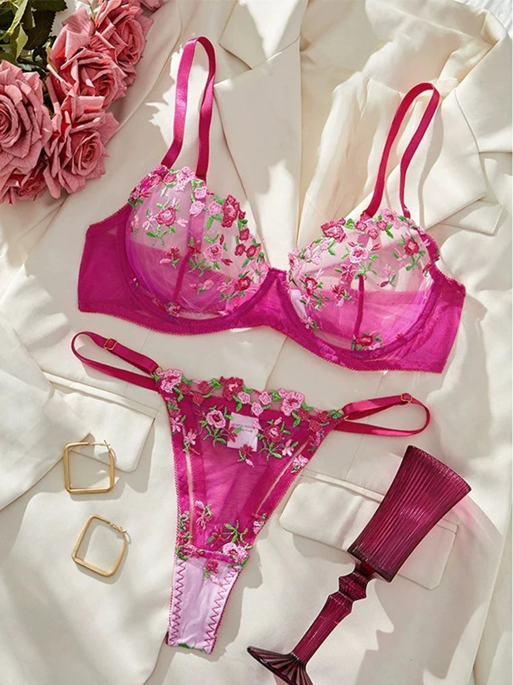 Pink floral lingerie set on a white surface with flowers and jewelry.