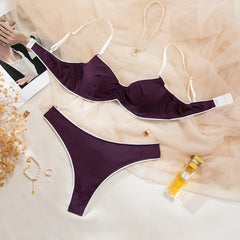 Purple bikini set on a light background with decorative items.