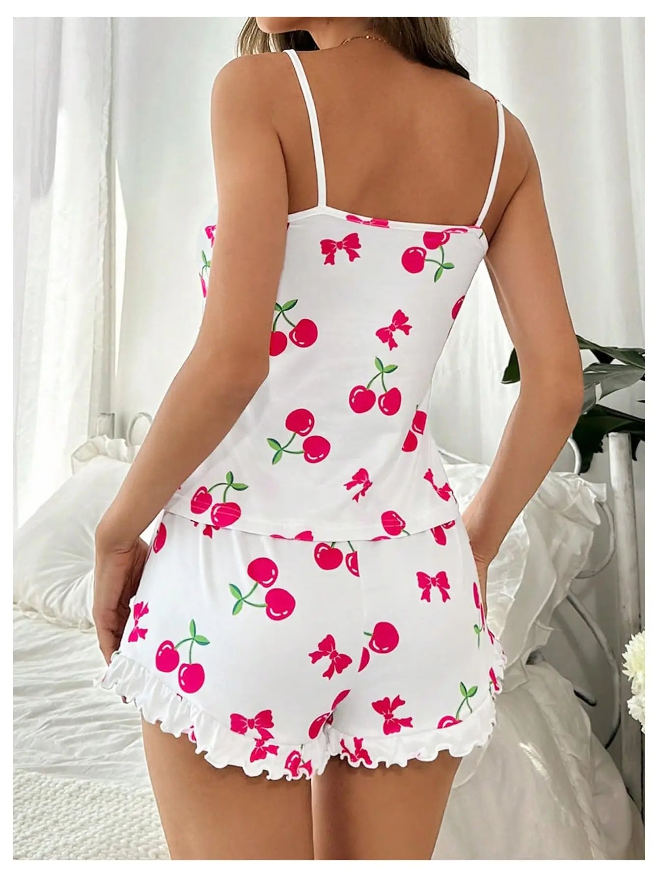 White nightgown with red cherries and green bows on a white background