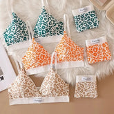 Set of leopard print bras and panties on a textured surface