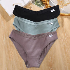 Two pairs of underwear, one black and one gray, on a wooden surface.
