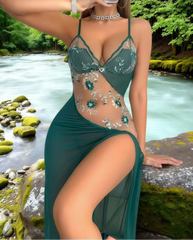 Woman wearing a green lace dress by a river with greenery in the background