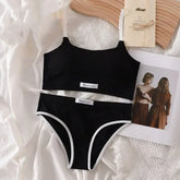 Black swimsuit with 'Fashion' label on a textured white surface