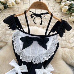 Black and white outfit with bows on a hanger against a floral background