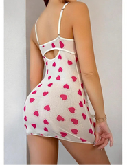 Woman wearing a sheer dress with pink heart patterns on a plain background