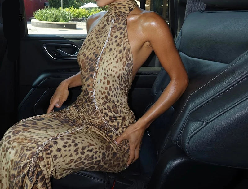 Woman in a leopard print dress sitting in a car