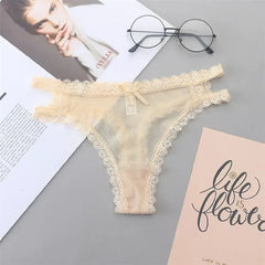 Beige lace thong on a gray surface with books and glasses in the background