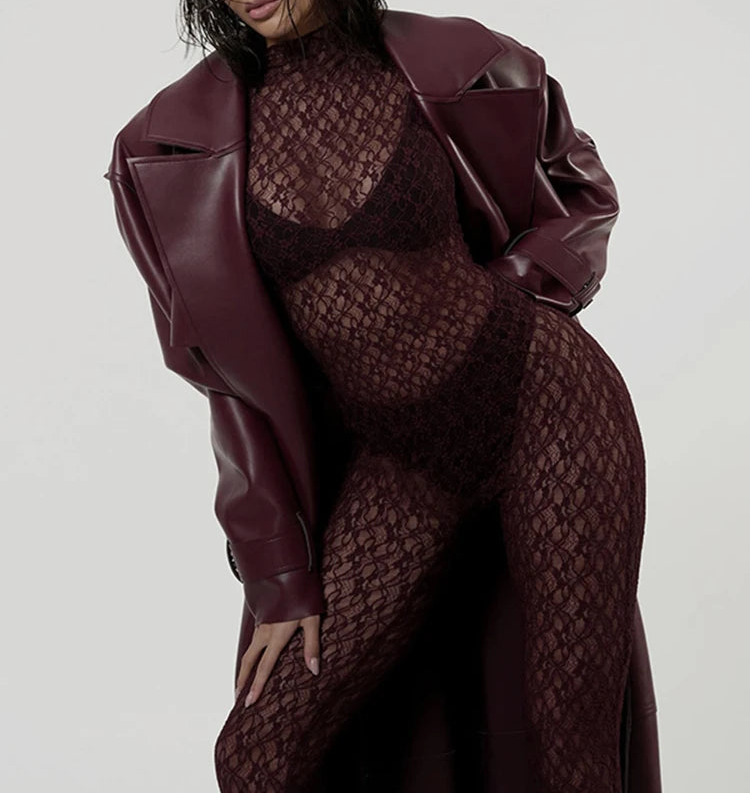 Person wearing a burgundy leather jacket and matching dress on a plain background