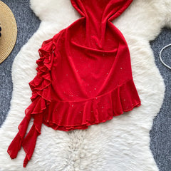 Red velvet top with ruffled details on a textured white surface