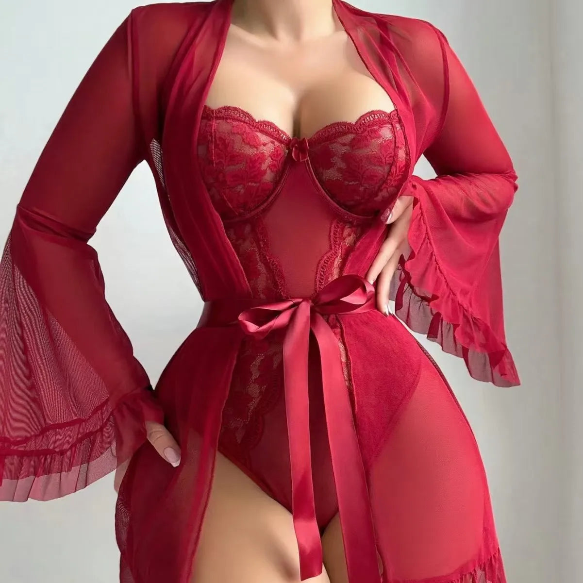 Red lace lingerie set with matching robe on a neutral background