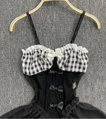 Black and white checkered top with lace details on a hanger against a textured gray background.