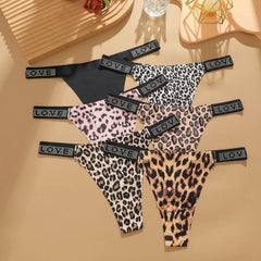 Leopard print lingerie set on a beige surface with decorative items.