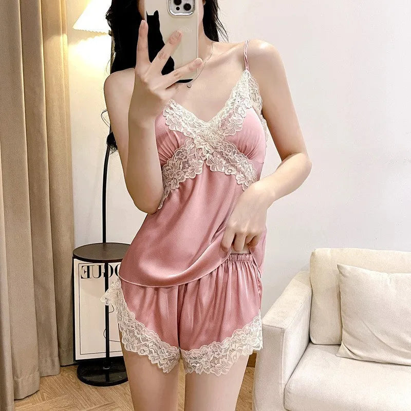 Woman wearing a pink satin nightgown with lace details in a room.