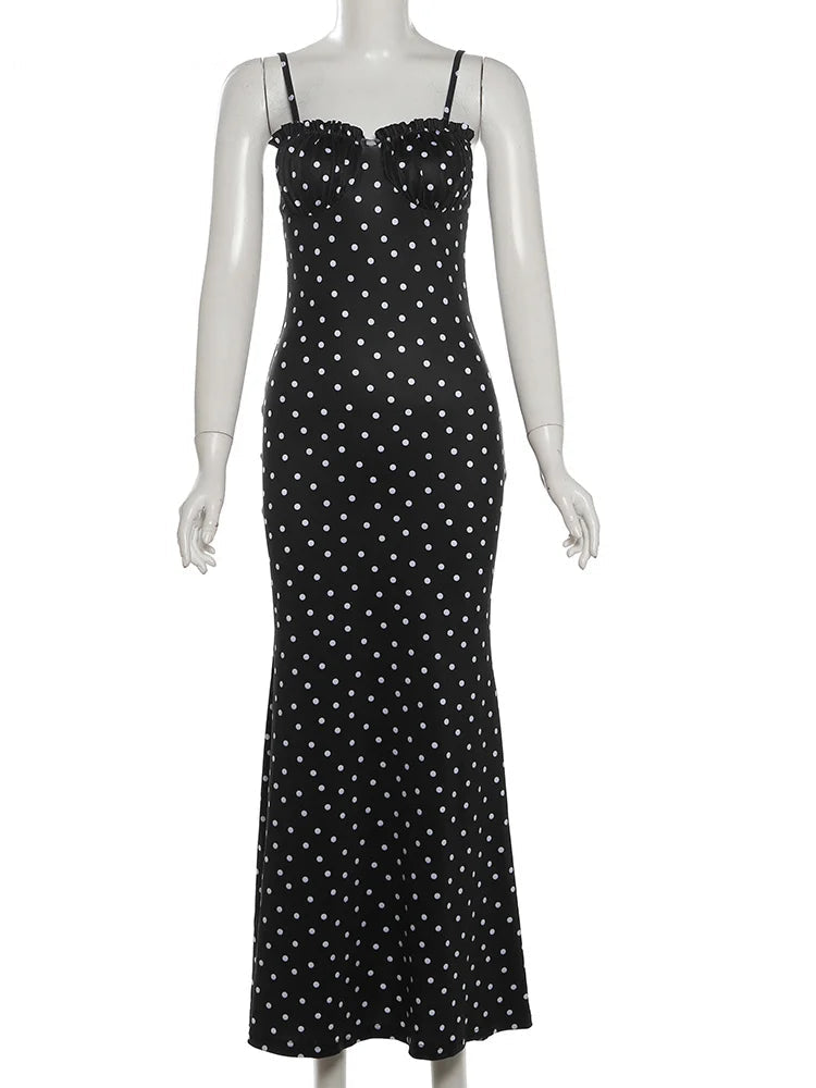 Black dress with white polka dots on a mannequin against a white background