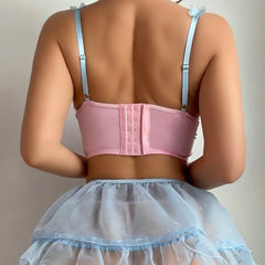 Person wearing a pink corset and light blue petticoat against a neutral background