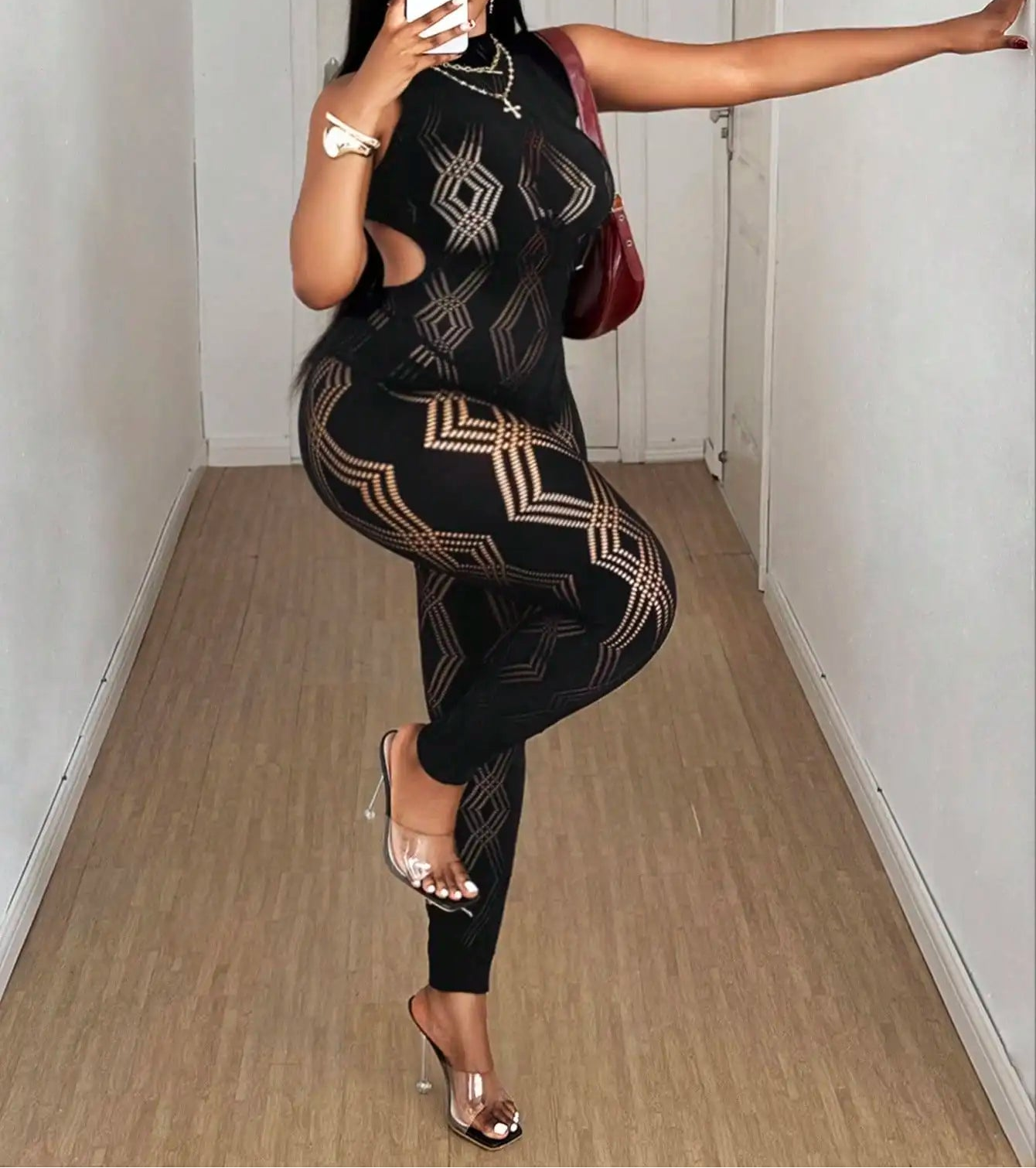 Person wearing a black and gold patterned outfit taking a mirror selfie.
