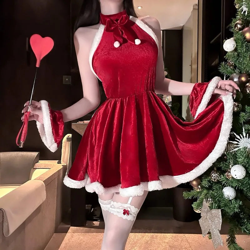 Person wearing a red velvet dress with white trim in a room with a Christmas tree.