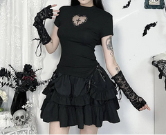 Person wearing a black outfit with lace gloves and a floral headpiece in a decorative setting.