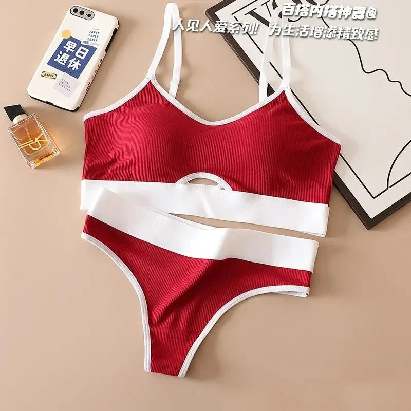 Red and white bikini set on a beige surface with a phone, perfume bottle, and framed picture.