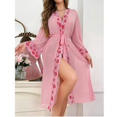 Pink robe with red floral patterns worn by a model in a decorative room.