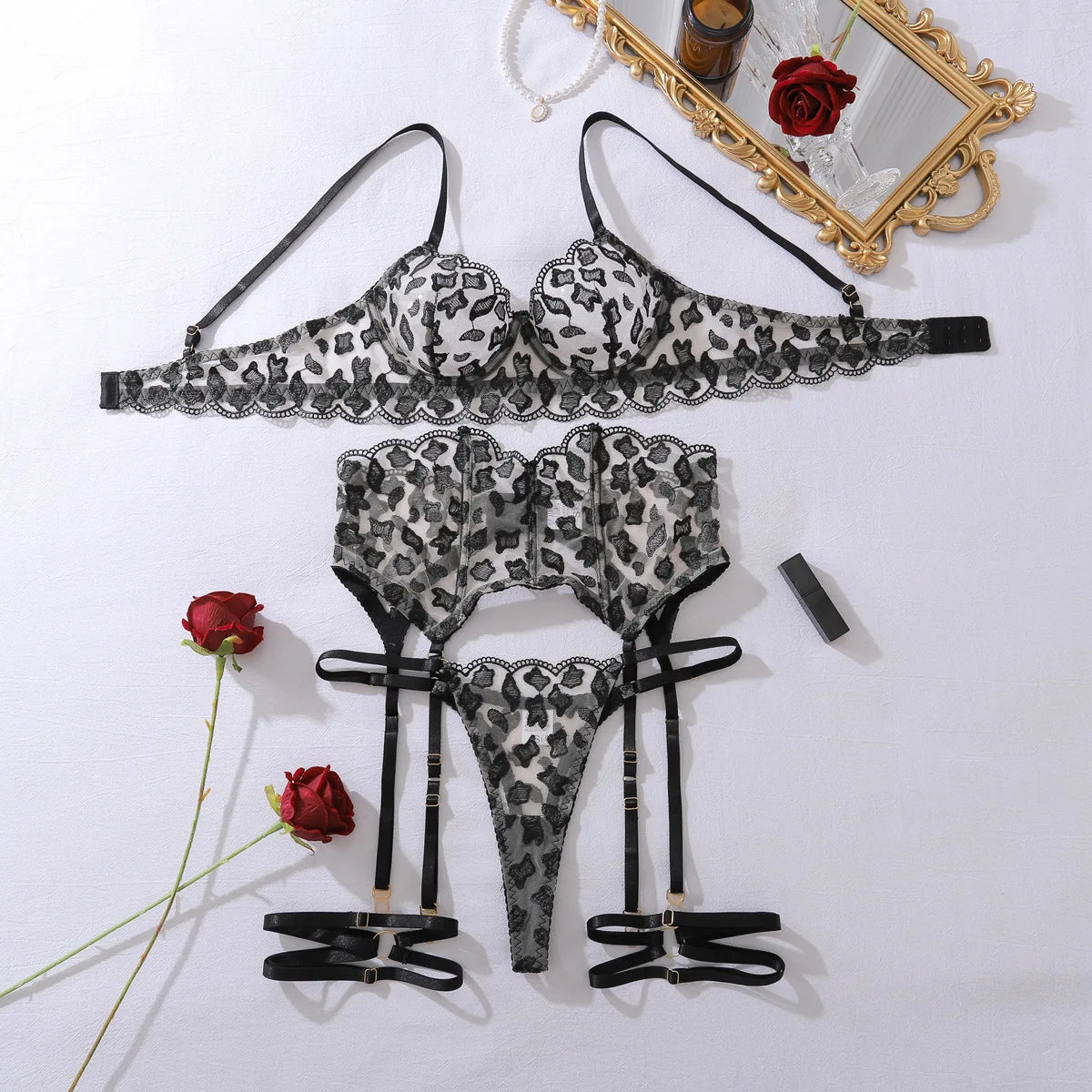 Leopard print lingerie set with roses and a mirror on a white background