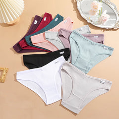 Assorted women's underwear in various colors on a beige surface.