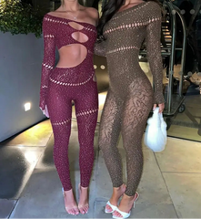 Two women wearing sheer, patterned outfits standing indoors.