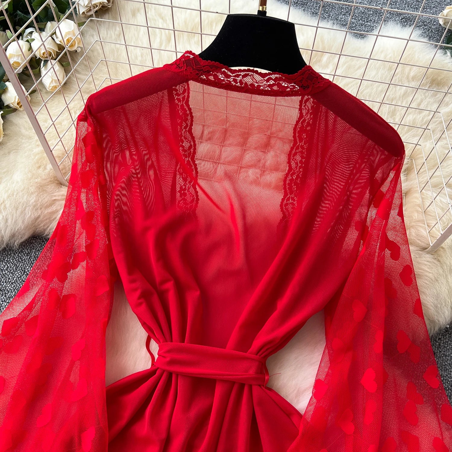 Red lace dress on a mannequin against a neutral background