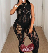 Person wearing a black geometric patterned outfit with a maroon handbag indoors.