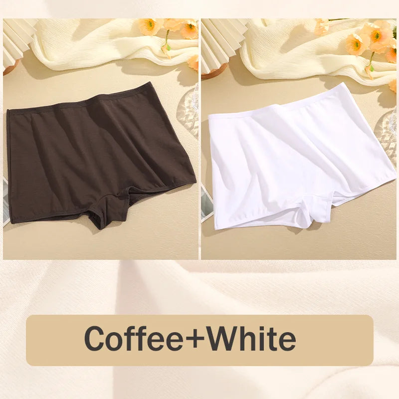 Two pairs of shorts, one brown and one white, on a beige surface with flowers in the background.