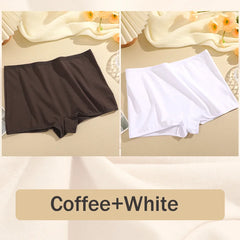Two pairs of shorts, one brown and one white, on a beige surface with flowers in the background.