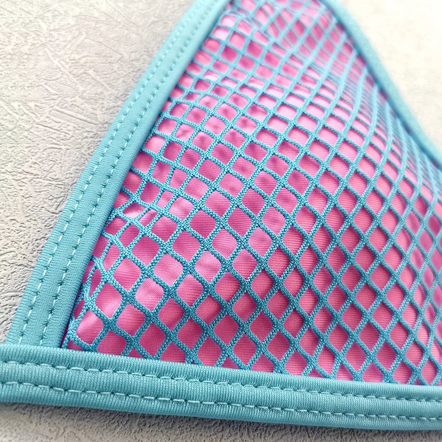 Close-up of a pink mesh pouch with blue trim on a light gray background