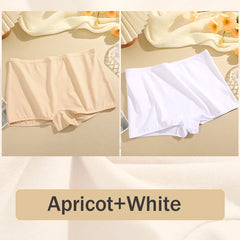 Two pairs of underwear, one apricot and one white, on a beige surface with flowers in the background.